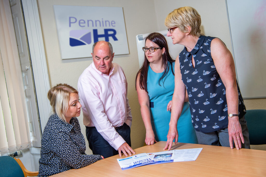 Pennine HR consultants reviewing a document
